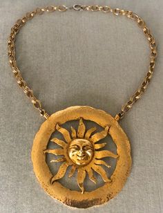 You are looking at a truly spectacular VINTAGE TORTOLANI MID CENTURY MODERNIST MASSIVE ALMOST 4" SUN FACE EXTRA BIG SCULPTURAL DIMENSIONAL ROUND MEDALLION PENDANT BREASTPLATE BIB ON CHAIN CHOKER COLLAR NECKLACE, completely done in Rich Gilt Gold-tone Metal, with an Avant-garde chic look reminiscent of Elsa Schiaparelli, SIGNED, Circa 1970's. VERY REPRESENTATIVE OF THE MID CENTURY MODERNIST CELESTIAL INSPIRED CREATIONS, THIS NECKLACE IS EXQUISITE IN ITS DESIGN AND IT WILL LOOK STUNNING WHEN BEING WORN FEATURING A MASSIVELY HUGE HAMMERED GOLD METAL ROUND MEDALLION CENTERPIECE THAT IS JUST SHY OF 4" IN DIAMETER, THIS SCULPTURAL CELESTIAL INSPIRED SUN CREATION IS JUST GORGEOUS IN ITS DESIGN, SHOWCASING REMARKABLE DIMENSIONAL DETAILS ON THE FACE AND THE RAYS OF THE SUN ITSELF, WHICH IS FRAMED B Medallion Necklace Vintage, Sun Medallion, Vintage Schiaparelli, Choker Necklace Gold, Designer Runway, Choker Collar Necklace, Elsa Schiaparelli, Sun Face, Gold Choker Necklace