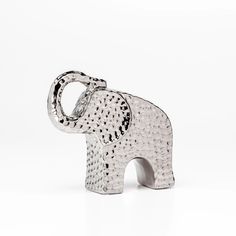 an elephant figurine made out of metal on a white background with no one around it