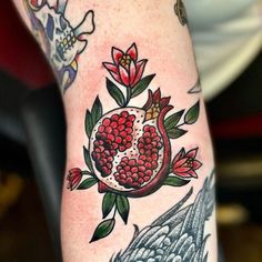 a woman's leg with tattoos on her legs and pomegranates