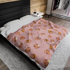 a bed covered in a pink blanket with brown bears on it