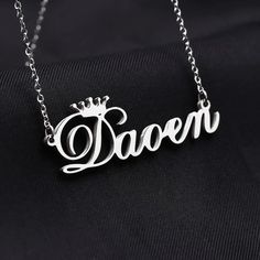 Personalized Crown Name Necklace is a personalized custom cursive font single name necklace gifted with the spirits of absolute glimmer. This beautiful piece of necklace with the queen's crown is an identical design that delivers the royal impression. The nameplate of the necklace can carry up to 10 letters of your choice for all the four types of custom chain lengths. Here we apply a crown symbol on top of the first letter of the name. Consider it as an added bonus to boost the prestigiousness Silver Jewelry With Custom Text For Birthday Gift, Customizable Silver Letter Name Necklace, Custom Silver Wedding Necklace With Names, Elegant Custom Text Nameplate Necklace, Silver Necklaces With Custom Text For Birthday, Silver Nameplate Necklaces With Custom Text, Custom Name Necklace In White Gold For Birthday, Silver Personalized Necklace For Birthday, Custom Text Silver Nameplate Necklaces