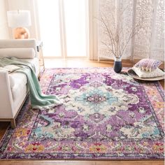 a living room area with a purple rug and white couches in front of a window