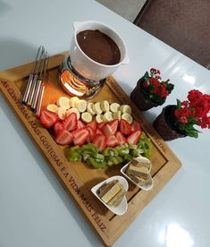 a tray with sliced up strawberries, bananas and other foods on it next to a cup of coffee