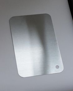 a metal plate sitting on top of a white table next to a laptop computer keyboard