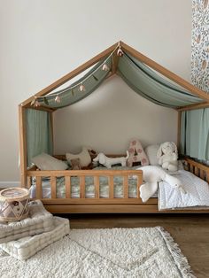 a child's bed with a canopy and pillows on the floor next to it