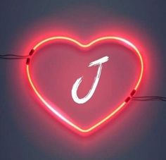 a heart shaped neon sign with the letter j on it