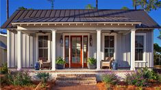 a small white house with porch and front door