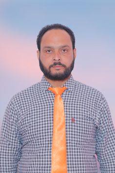 a man wearing an orange tie standing in front of a blue sky