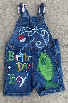 a pair of blue jean shorts with the words birth day boy on it and an image of a fish