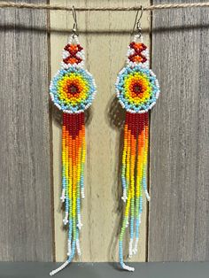 "Thank you to stopping by my shop You will love these large tassel earrings These earrings are super cute!  They're light but an awesome statement piece. Great for a Christmas Gift, mother's day, Birthday gift, gifts for her or any day of the year! 1\" x 6.5\"long" Rainbow Beaded Fringe Earrings For Gift, Festival Fringe Earrings With Round Beads, Traditional Beaded Fringe Earrings For Summer, Artisan Beaded Earrings With Tassels For Festival, Bohemian Beaded Dangle Earrings With Tassels, Rainbow Tassel Earrings For Gifts, Handmade Tassel Earrings For Festivals, Artisan Multicolor Beaded Tassel Earrings, Bohemian Beaded Tassel Dangle Earrings