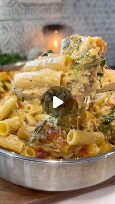 a pan filled with pasta and broccoli covered in cheese