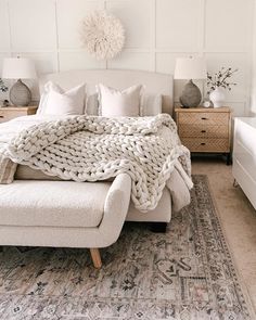 a white bed sitting in a bedroom next to a dresser