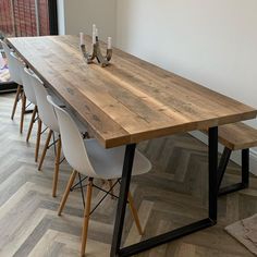 a long wooden table with white chairs around it