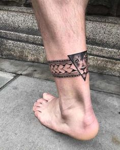 a man's foot with a black and white tattoo design on the side of his leg