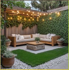 an outdoor living area with wooden furniture and string lights