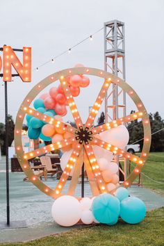 a ferris wheel decorated with balloons and lights