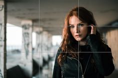 a woman with red hair is standing in front of a tiled wall and looking at the camera