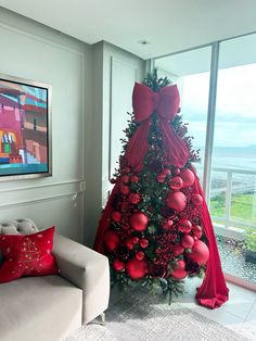 A stunning red Christmas tree adorned with a large red bow on top and decorated with red ornaments. This monochromatic holiday design creates an elegant and bold statement, perfect for adding festive cheer in a unique way. #RedChristmasTree #HolidayDecor #ChristmasBow #MonochromaticChristmas #FestiveDecor #ChristmasOrnaments #HolidayInspiration #ElegantChristmas Bow Decorated Christmas Tree, Large Bows On Christmas Tree, Red Bow Christmas Tree Decorating Ideas, Large Bow On Christmas Tree, Christmas Tree Decorated With Bows, Large Bow Christmas Tree, Bow On Top Of Christmas Tree, Red Decorated Christmas Trees, Large Ornaments On Tree