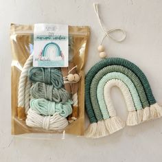 two pieces of yarn in bags on a white surface next to each other, one with a string and the other with tassels