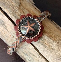 a wooden bench with a metal star on it's center and braiding around the edge