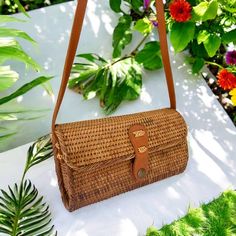 Hand-crafted from natural rattan, this rectangular handbag/clutch showcases a snap closure and adjustable crossbody strap for versatile use. Its fabric lining adds an extra touch of durability and versatility. Natural Rattan Size: Length: 8-1/8 | Depth: 3 inches | Height - 5 inches Snap Closure Rectangular Brown Strap Color: Natural Natural Rectangular Straw Bag With Detachable Strap, Rectangular Natural Straw Bag With Detachable Strap, Natural Clutch Shoulder Bag With Leather Handles, Travel Rectangular Straw Bag With Detachable Strap, Rectangular Woven Satchel For Travel, Woven Rectangular Satchel For Travel, Trendy Rectangular Straw Bag With Detachable Strap For Vacation, Rectangular Straw Bag With Detachable Strap For Vacation, Rectangular Vacation Straw Bag With Detachable Strap