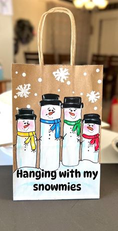 a paper bag with three snowmen on it and the words hanging with my homings