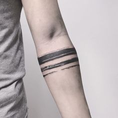 a man's arm with a black and white striped tattoo on his left wrist