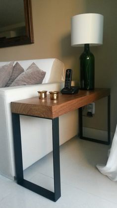 a white couch sitting next to a wooden table with a phone on top of it