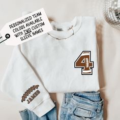 2 Names Football Mom Sweatshirt with Custom Number, That's My Boys, Football Mom Hoodie, Custom Football Mom Crewneck Sweater, Personalized Football Mom The Gildan 18000 sweatshirt is made from a heavy blend of cotton and polyester, making it perfect for any situation. The ribbed knit collar will keep your neck warm, and the garment is machine-washable, so you can be sure it will look fresh and beautiful even after repeated washes.  Introducing the Ultimate Comfort Unisex Heavy Blend Hooded Swea Team-colored Long Sleeve Pre-shrunk Hoodie, Fall College Hoodie Pre-shrunk, Fall College Crew Hoodie, White Hoodie For College In Fall, Fall Team Spirit Pre-shrunk Hoodie, White School Spirit Sweatshirt With Ribbed Cuffs, Team Spirit Long Sleeve Winter Sweatshirt, White Sweatshirt With Ribbed Cuffs For School Spirit, Team Spirit Fleece Hoodie For Fall