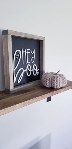 a wooden shelf with a chalkboard sign that says hey 2009 and a crocheted pumpkin