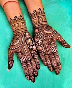 two hands with henna tattoos on them