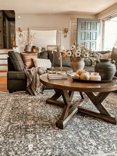 a living room filled with furniture and flowers on top of a table in front of a couch