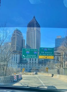 there are many street signs on the side of the road with buildings in the background