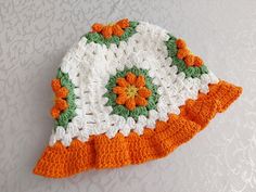 an orange and white crocheted hat sitting on top of a table