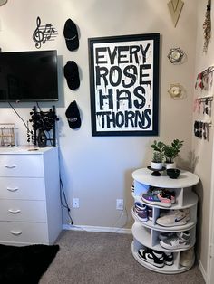 a room with a white dresser, black and white wall art