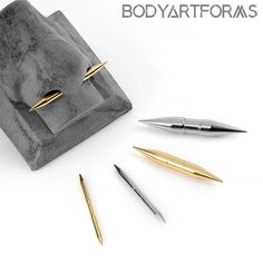 four different types of pen and pencils sitting on top of a stone block with the words bodyartfoams written above it