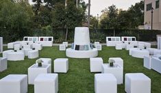 white cubes are arranged on the grass in front of a building