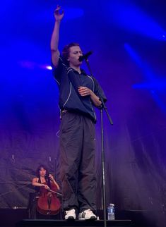 a man standing on top of a stage holding a microphone