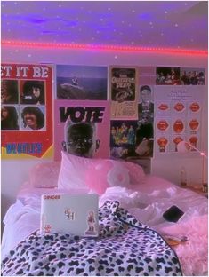 a bed room with a laptop computer on it's side and pictures on the wall