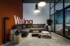 a living room with couches and tables in front of a wall that says waiting