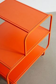 an orange table sitting on top of a cement floor