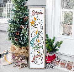 a wooden sign that says believe with snowmen on it and christmas trees in the background