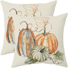 two pillows with pumpkins and leaves on them