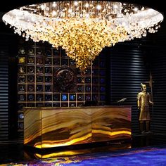 a large chandelier hanging from the ceiling above a reception table in a lobby