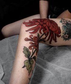 a woman laying on top of a bed covered in tattoos