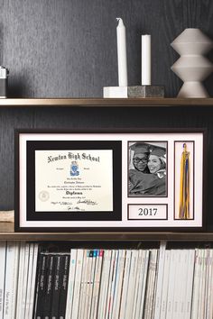 a framed diploma certificate on top of a book shelf filled with books and cds in front of a black wall