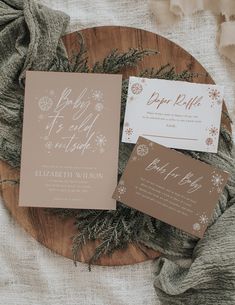 the wedding stationery is laid out on a wooden plate