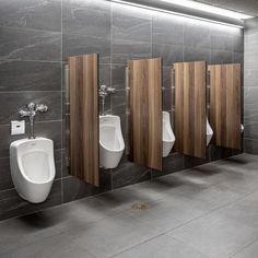 a row of urinals mounted to the side of a wall in a bathroom