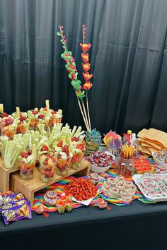 an assortment of candy and candies on a table at a party or event with black backdrop