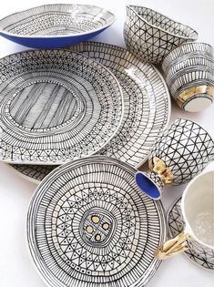 an assortment of plates and bowls with designs on them, sitting next to each other